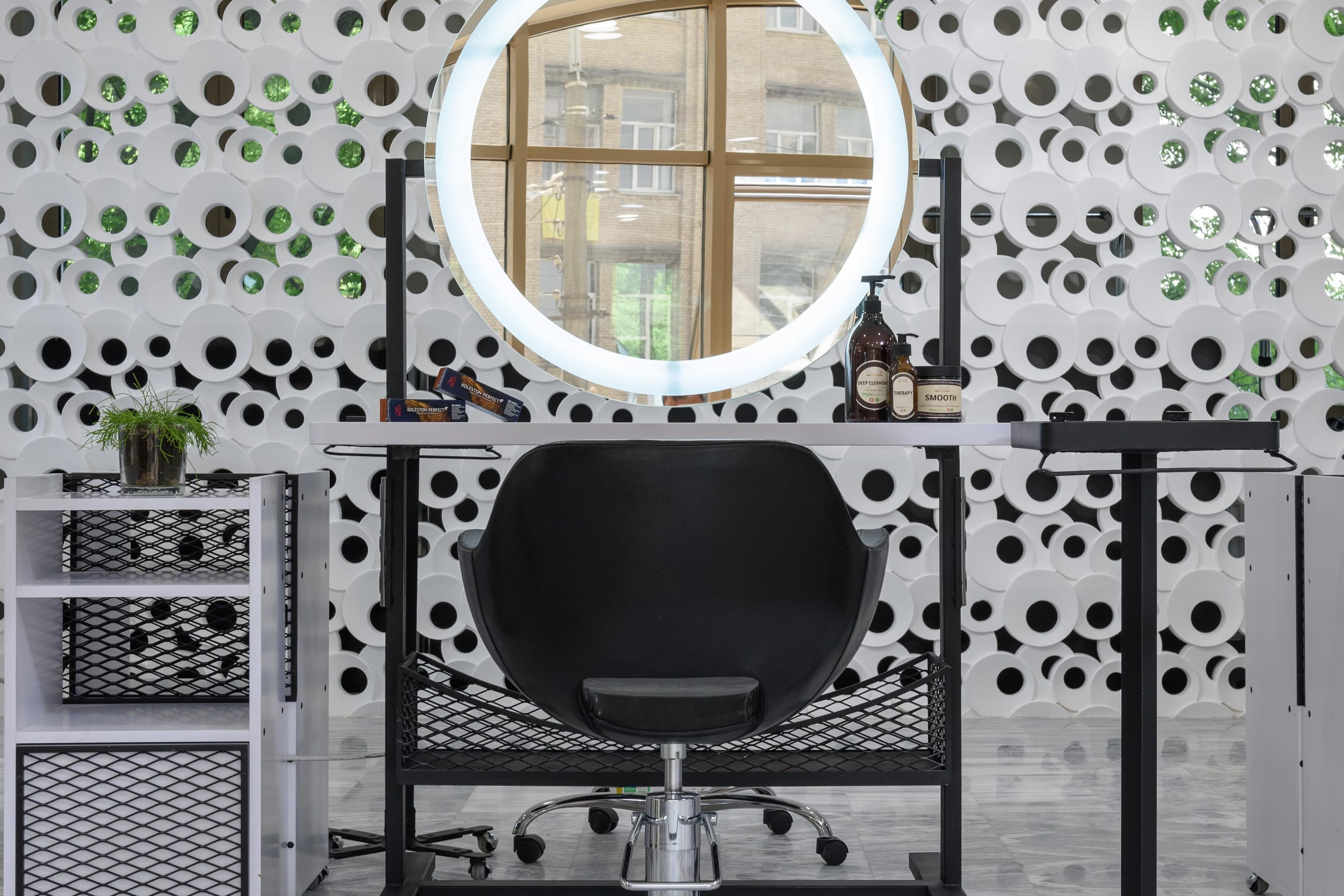 Salon interior with a row of mirrors, cream walls and warm pendant lights